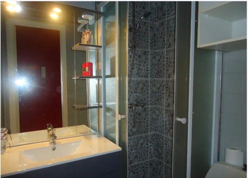 une salle de bain avec un lavabo et une douche avec un miroir dans l'établissement Studios à Golfe juan, au Golfe-Juan