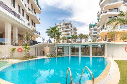 a swimming pool in front of a building at Luxury Penthouse Allonbay Village & SPA in Villajoyosa