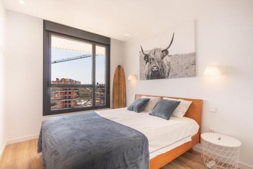 ビリャホヨサにあるLuxury Penthouse Allonbay Village & SPAのベッドルーム1室(壁に牛の写真が飾られたベッド1台付)