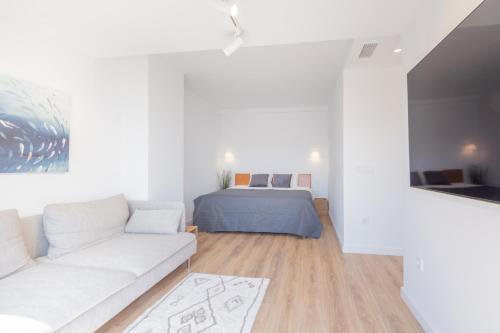 a white living room with a couch and a bed at Luxury Penthouse Allonbay Village & SPA in Villajoyosa