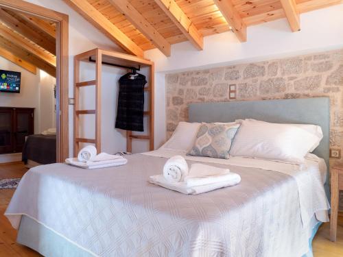 a bedroom with a bed with towels on it at Captain's Memories Stylish Harbour Apartments in Halki