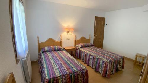 a room with two beds and a table in it at C13 - Apartamento Casa Llorgodo 4 - Villmor in Cerler
