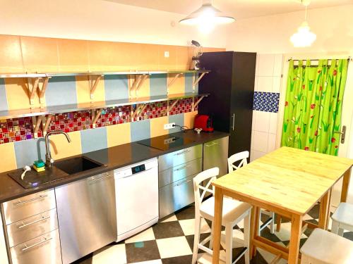 eine Küche mit einem Tisch, einer Spüle und einem Geschirrspüler in der Unterkunft Blumental Apartment II in Wien