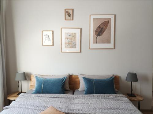 een slaapkamer met een bed met blauwe kussens en foto's aan de muur bij Das Kornburg-Quartier in Neurenberg