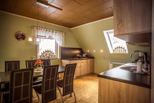 uma cozinha com mesa e cadeiras num quarto em Ferienhof Kürschner em Drebach
