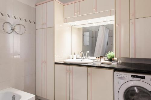 a bathroom with a sink and a washing machine at Signature 2BR Apartment in Marousi by UPSTREET in Athens