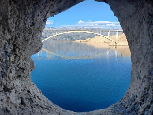 a view of a bridge from a hole in a rock at Apartmani Branka in Rtina