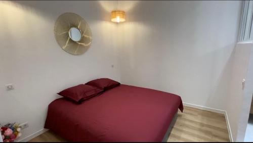 een slaapkamer met een rood bed en een ventilator bij Ajaccio T2 Standing Place du marché in Ajaccio