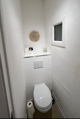 een witte badkamer met een toilet en een spiegel bij Ajaccio T2 Standing Place du marché in Ajaccio