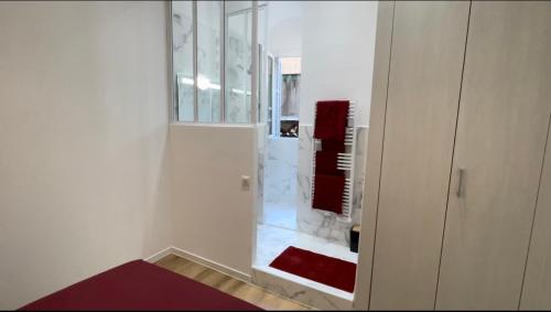 een witte badkamer met een spiegel en een rood tapijt bij Ajaccio T2 Standing Place du marché in Ajaccio