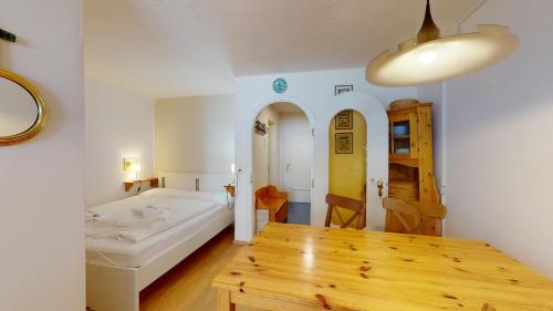 una camera con letto e tavolo in legno di Guardaval 13 a Surlej