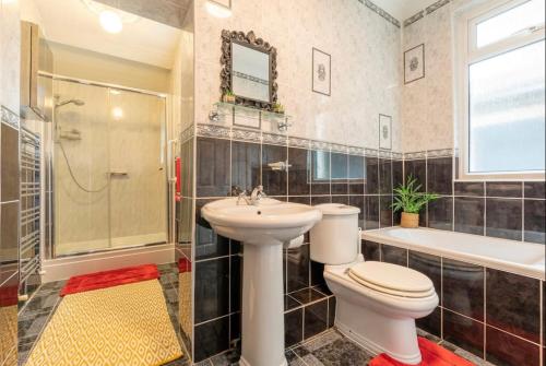 a bathroom with a toilet and a shower and a sink at Shelley’s Seaside Stay (Garden/ Double Drive) in Porthcawl