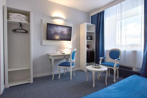 a hotel room with a bed and a desk and chairs at MyContinental Bucuresti Gara de Nord in Bucharest