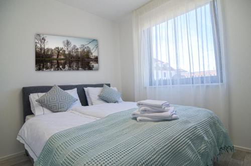 a bedroom with two beds with towels on them at Palm Garden Apartment 1 in Mikulov