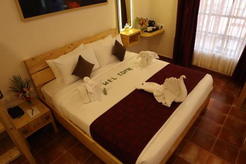 a bedroom with a large bed with towels on it at Royal Destiny Resort in Malaiyāndipattanam