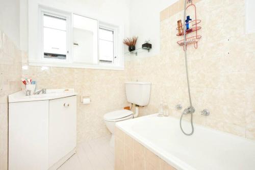 een badkamer met toilet, wastafel en douche bij Beach to home in 3 minutes: Bondi N in Sydney
