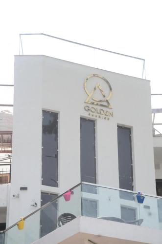a white building with a golden sign on it at The Golden Sunrise Hotel in Nainital