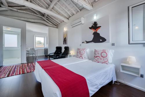 a bedroom with a large bed with a red blanket at Olala Fine Arts Studios in Porto