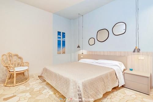 1 dormitorio con cama, silla y espejos en Torre Scola, Terre Marine, en Portovenere