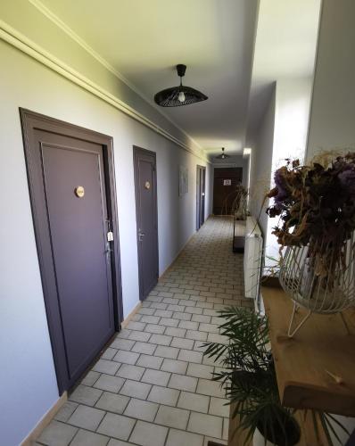 a hallway with a door and a tile floor at Domaine de la Ferme de Jean Grogne in Fontenay-Trésigny