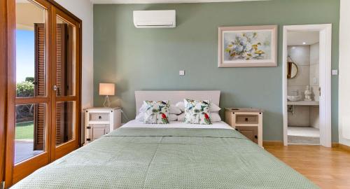 a bedroom with a large bed with two pillows at Apartment KZ01 - Modern ground floor apartment in the heart of Aphrodite Hills Resort in Kouklia