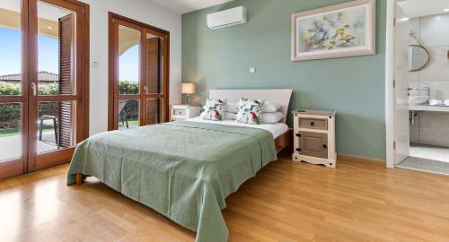 a bedroom with a bed with pillows and a table at Apartment KZ01 - Modern ground floor apartment in the heart of Aphrodite Hills Resort in Kouklia