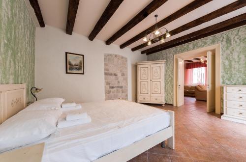 een slaapkamer met een groot wit bed in een kamer bij Apartments Leo in Kotor