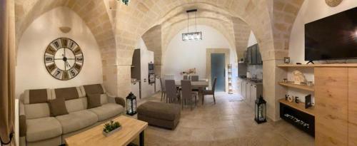a living room with a couch and a clock on the wall at LATA LUXURY HOME CASA VACANZE in Brindisi