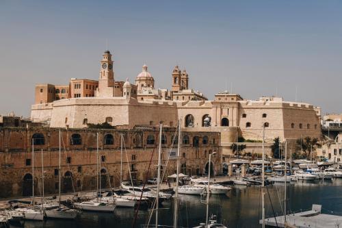 a group of boats in a harbor in front of a building at Dock 1 Boutique Hotel in Cospicua