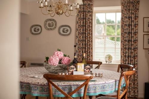 a dining room table with a bowl of flowers on it at Balnagown Estates in Kildary