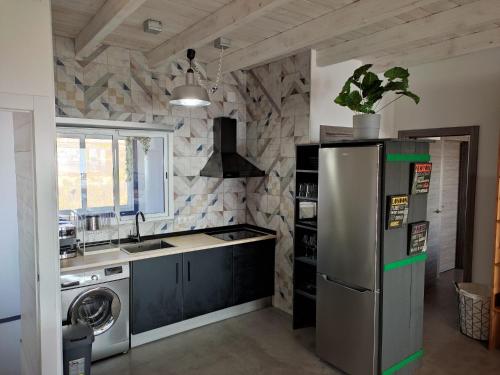 a kitchen with a stainless steel refrigerator and a sink at Apartamento y Estudio Torre Vigía in Morche
