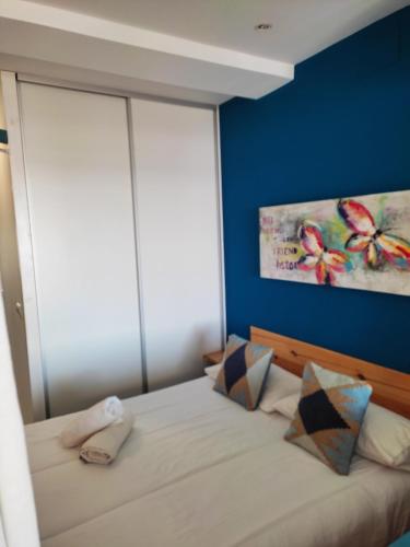 a bed in a bedroom with a blue wall at Apartamento y Estudio Torre Vigía in Morche