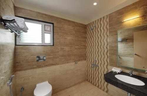 uma casa de banho com um WC, um lavatório e uma janela em Hotel Fortune em Rameswaram