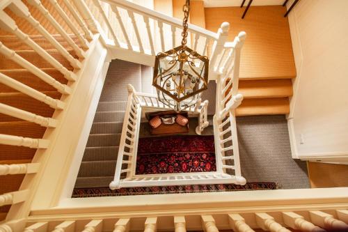 a stairway with a chandelier and a staircase with a staircase at Balnagown Estates in Kildary