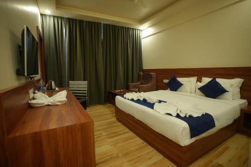 a bedroom with a bed and a desk and a television at HOTEL MAKHAN VIHAR in Ambikāpur