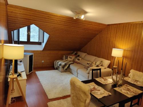 ein Wohnzimmer mit einem Sofa und einem Tisch in der Unterkunft La Moleta Canfranc in Canfranc