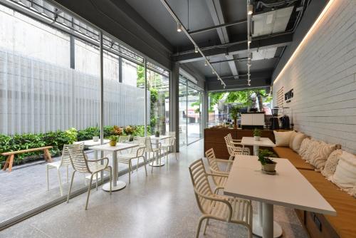 a restaurant with tables and chairs and windows at Tiang Capsule in Bangkok