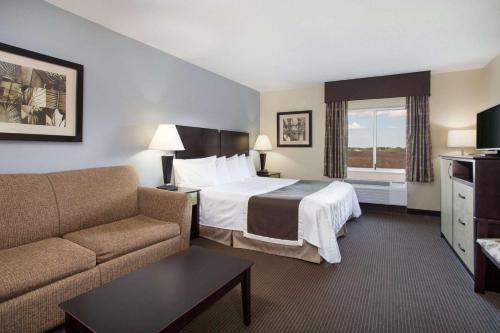 a hotel room with a bed and a couch at Baymont by Wyndham Dale in Dale