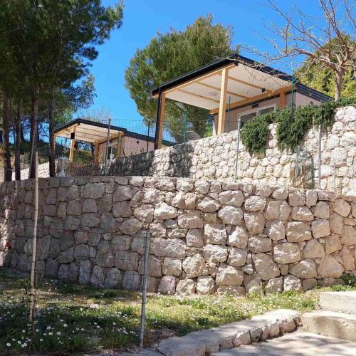 a stone wall with a house on top of it at Lavanda Mobile Homes & Villas in Orebić