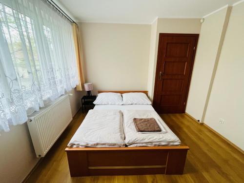 a bedroom with a bed and a large window at Apartament Słoneczny Willa Perla 100m od morza in Gdańsk