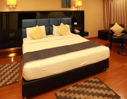 a bedroom with a large bed with yellow pillows at Quality Inn Bez Krishnaa in Visakhapatnam