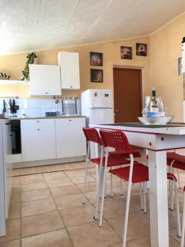 een keuken met witte kasten en rode stoelen bij Casa Scirocco IUN Q2421 in Pula