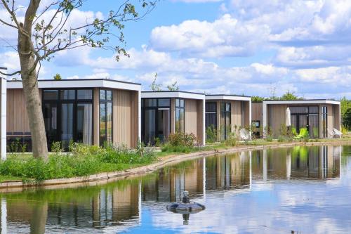 a row of modular houses next to a river at EuroParcs Marina Strandbad in Olburgen