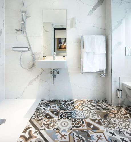 a bathroom with a sink and a mirror at Eiffel Petit Louvre in Paris