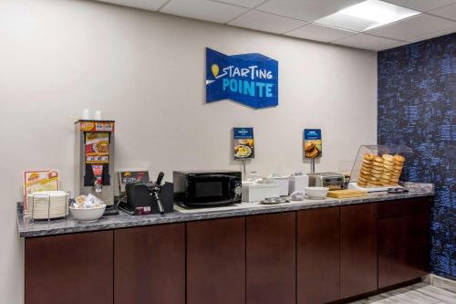 a fast food counter with a sign on the wall at Clarion Pointe Charlottesville in Charlottesville