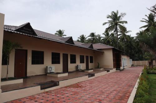 a building with a brick walkway in front of it at Royal Destiny Resort in Malaiyāndipattanam