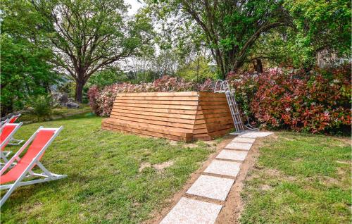 a garden with two chairs and a wooden wall at Lovely Home In Santa Maria Albiano in Santa Maria Albiano