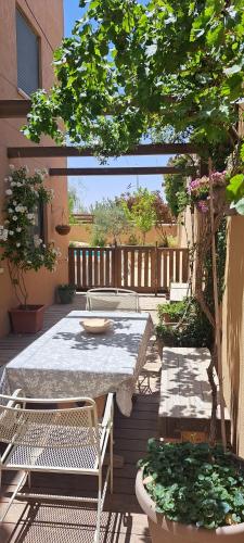 a patio with a table and chairs and a tree at Desert Rose in Midreshet Ben Gurion