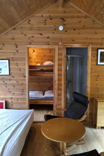 a bedroom with a bunk bed and a wooden table at Sæbø Camping in Eidfjord