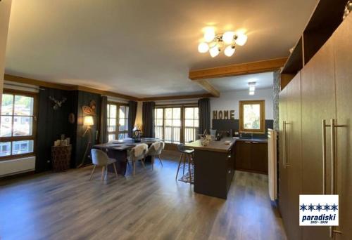 une cuisine et un salon avec une table et des chaises dans l'établissement Stylish ski-in ski-out 3 bed apartment, Arc 1950, à Arc 1950